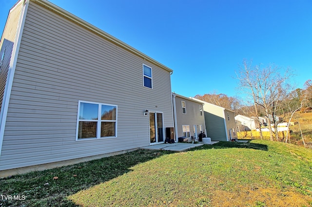 back of property with a lawn and a patio area