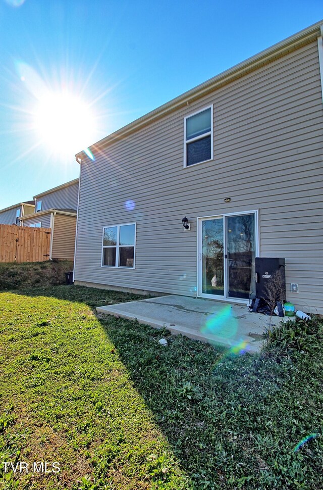 back of house with a yard and a patio