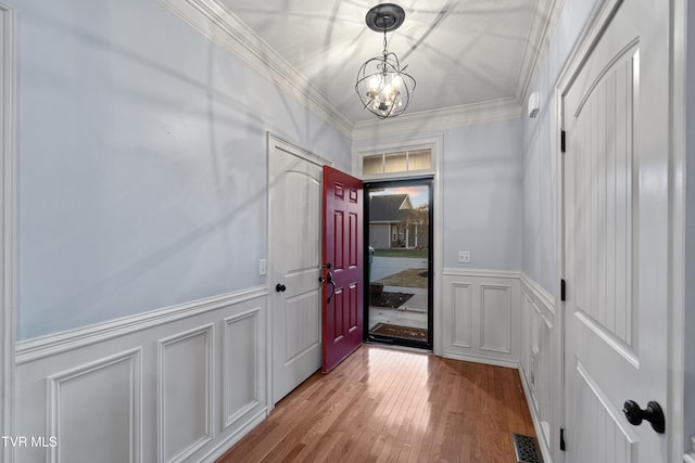interior space featuring a notable chandelier, light hardwood / wood-style floors, and crown molding