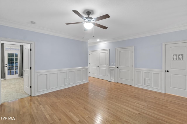 spare room with ceiling fan, light wood-type flooring, and crown molding