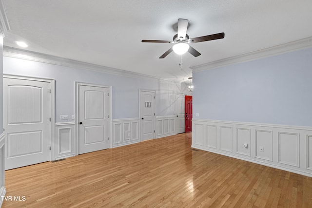 spare room with crown molding, ceiling fan, and light wood-type flooring