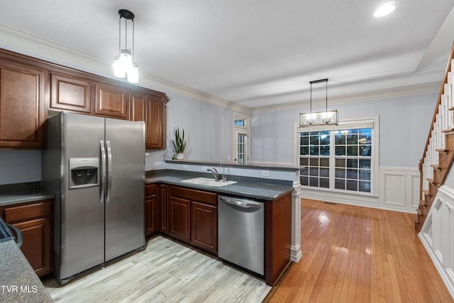 kitchen with kitchen peninsula, hanging light fixtures, and stainless steel appliances