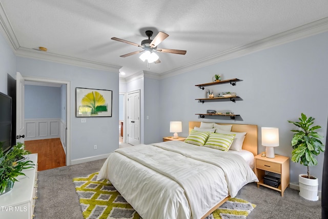 carpeted bedroom featuring a textured ceiling, a closet, ceiling fan, and ornamental molding