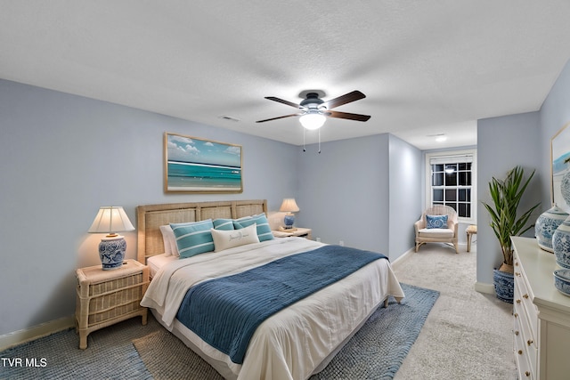 bedroom with light carpet, a textured ceiling, and ceiling fan