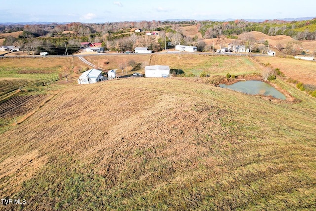 birds eye view of property featuring a water view and a rural view