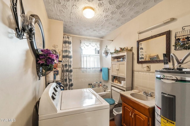 clothes washing area featuring electric water heater, sink, tile walls, and washer / dryer