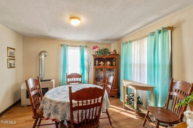 dining space featuring light hardwood / wood-style floors and a textured ceiling