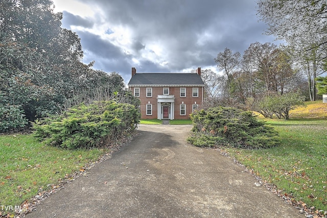 colonial home with a front lawn