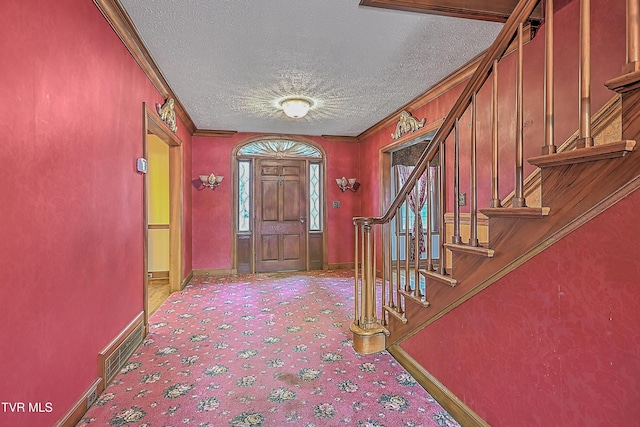 carpeted entrance foyer featuring ornamental molding and a textured ceiling