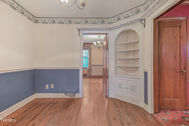 interior space featuring a chandelier, hardwood / wood-style floors, and built in features