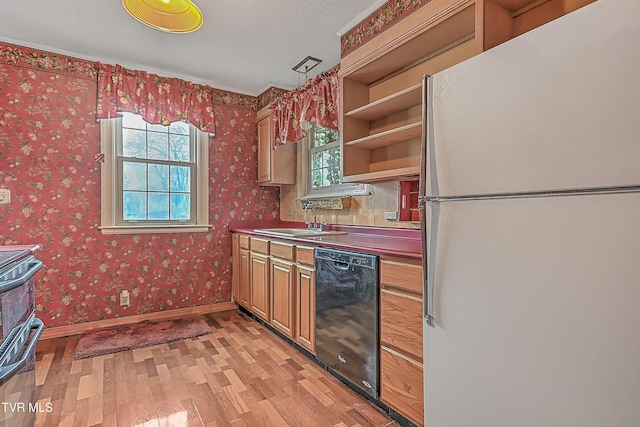 kitchen with sink, black dishwasher, white refrigerator, stove, and light hardwood / wood-style floors