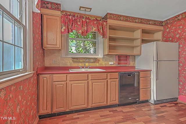 kitchen featuring a wealth of natural light, dishwasher, white fridge, and light wood-type flooring