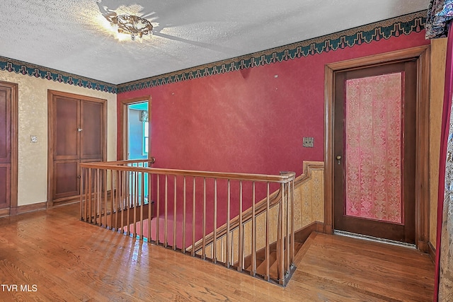 hallway with wood-type flooring and a textured ceiling