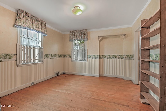 spare room with hardwood / wood-style floors and crown molding