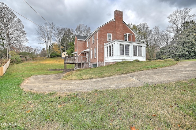 view of home's exterior featuring a lawn and a wooden deck