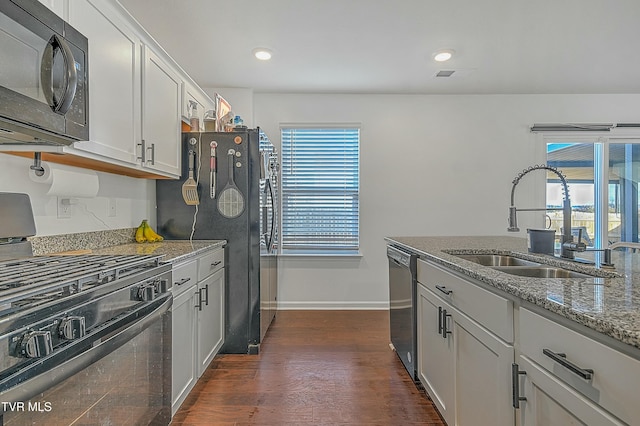 kitchen featuring light stone countertops, sink, dark hardwood / wood-style flooring, white cabinets, and black appliances