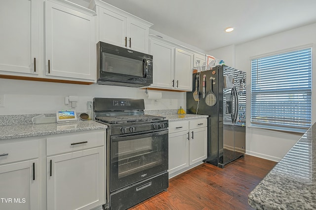 kitchen with black appliances, dark hardwood / wood-style flooring, white cabinetry, and light stone counters