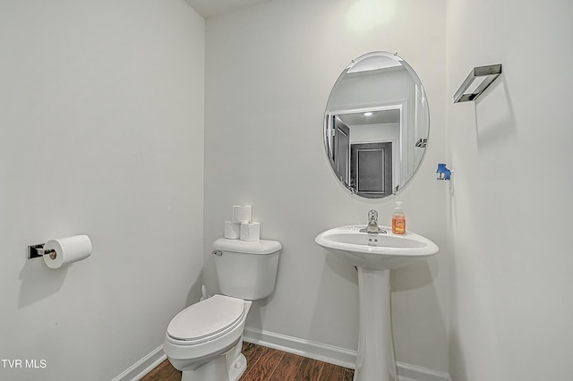 bathroom with hardwood / wood-style flooring, toilet, and sink