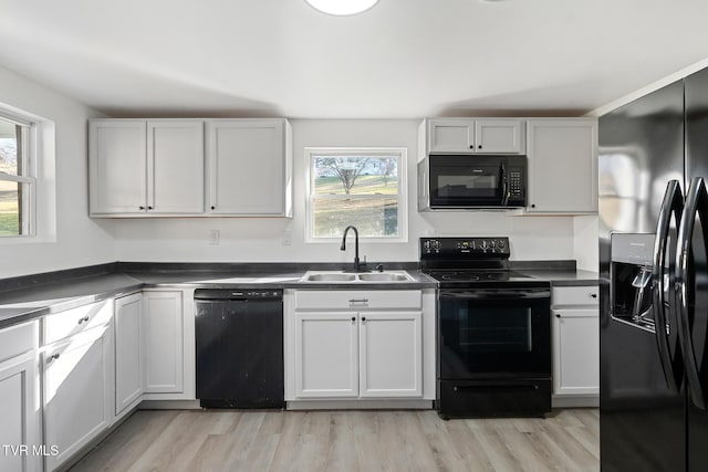 kitchen with white cabinetry, sink, plenty of natural light, and black appliances