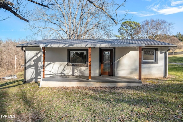 back of house featuring a patio area and a lawn