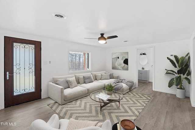 living room featuring ceiling fan and light wood-type flooring