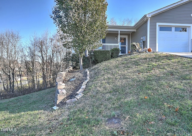 view of front of property featuring covered porch, a front yard, and a garage