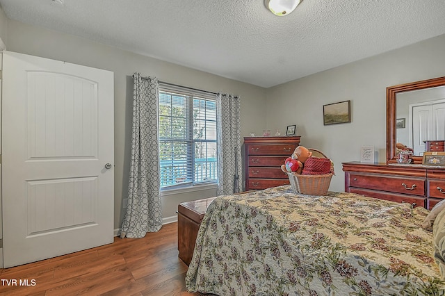 bedroom featuring wood-type flooring and a textured ceiling