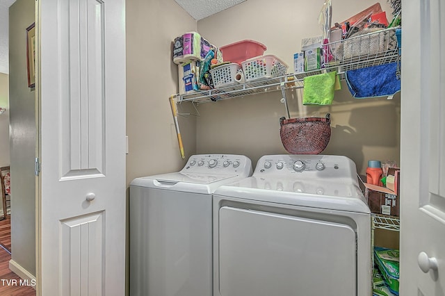 laundry area with hardwood / wood-style floors, a textured ceiling, and independent washer and dryer