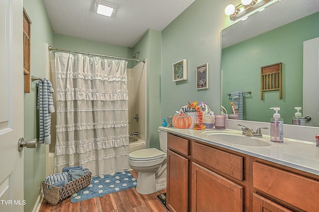 full bathroom with vanity, hardwood / wood-style floors, a textured ceiling, and shower / bath combo with shower curtain