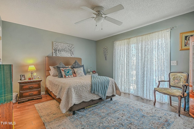 bedroom featuring a textured ceiling, light hardwood / wood-style floors, and ceiling fan