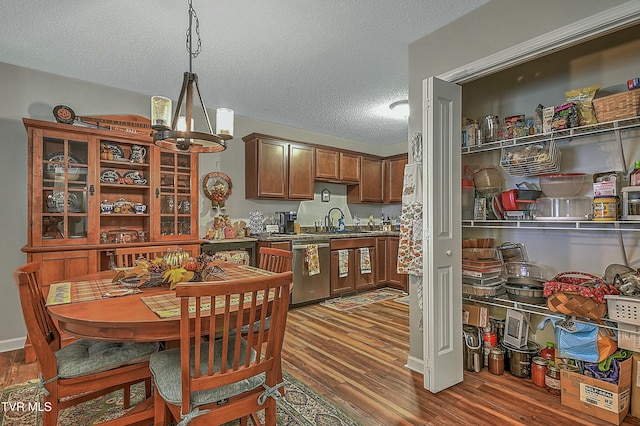 kitchen with dishwasher, dark hardwood / wood-style floors, a notable chandelier, pendant lighting, and a textured ceiling