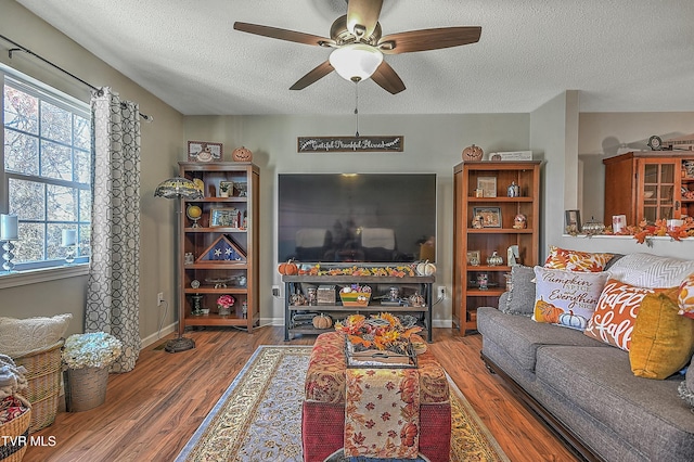 living room with wood-type flooring, a textured ceiling, and ceiling fan