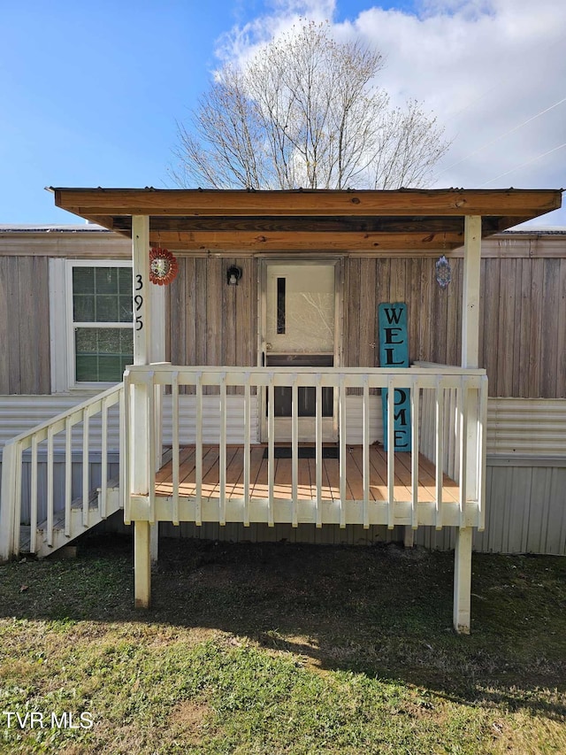 rear view of property featuring a wooden deck