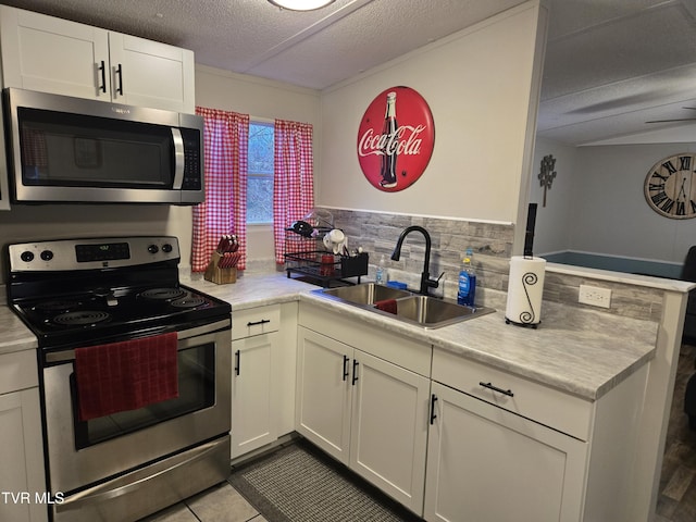 kitchen featuring appliances with stainless steel finishes, backsplash, sink, white cabinets, and light tile patterned flooring