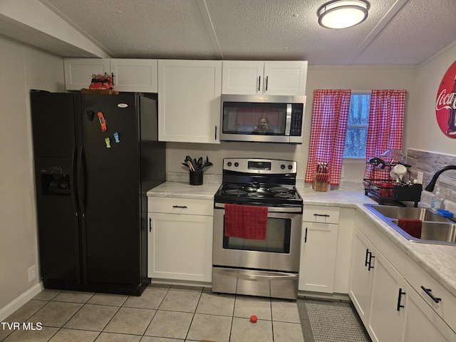 kitchen with white cabinets, sink, stainless steel appliances, and a textured ceiling