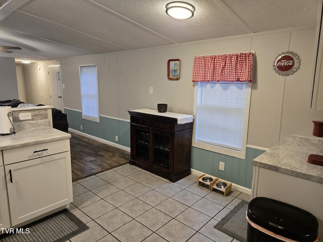 kitchen with white cabinetry, ceiling fan, light hardwood / wood-style floors, and a textured ceiling