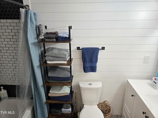 full bathroom featuring vanity, wood walls, toilet, and shower / bath combo with shower curtain