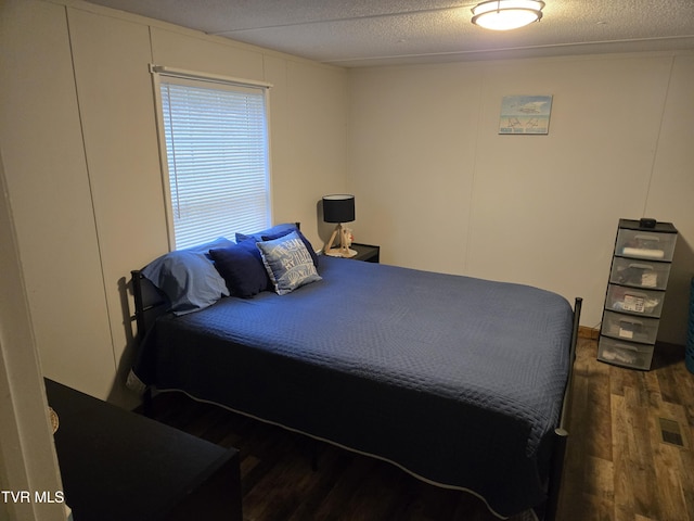 bedroom featuring dark hardwood / wood-style flooring and a textured ceiling