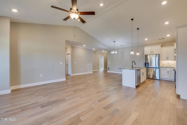 kitchen with sink, tasteful backsplash, an island with sink, decorative light fixtures, and appliances with stainless steel finishes