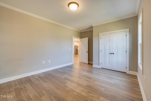 unfurnished bedroom with a closet, ornamental molding, and light hardwood / wood-style flooring