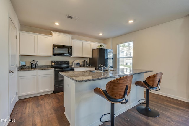 kitchen with dark wood-type flooring, sink, white cabinets, and black appliances