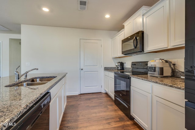 kitchen featuring light stone counters, dark wood-type flooring, sink, black appliances, and white cabinetry