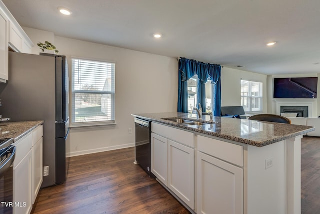 kitchen featuring appliances with stainless steel finishes, plenty of natural light, an island with sink, and sink