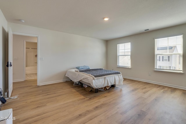 bedroom with light hardwood / wood-style flooring and multiple windows