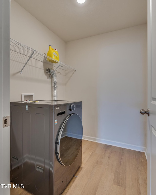 washroom with washer / clothes dryer and light hardwood / wood-style flooring