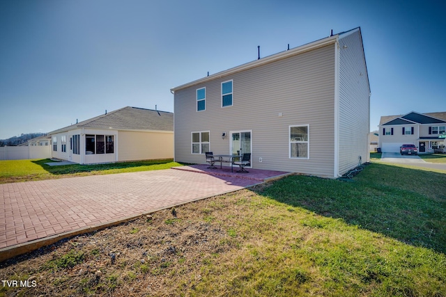 rear view of property with a yard and a patio