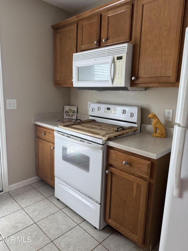 1505 Kensington Pl Unit 1505, Johnson City, TN 37615 - kitchen with white appliances, light tile patterned floors, light countertops, baseboards, and brown cabinetry