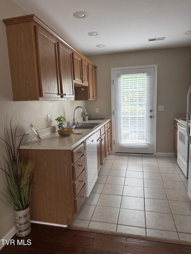 1505 Kensington Pl Unit 1505, Johnson City, TN 37615 - kitchen featuring a sink, white appliances, brown cabinetry, light countertops, and baseboards