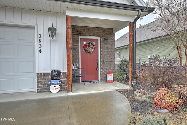 view of exterior entry featuring a porch and a garage