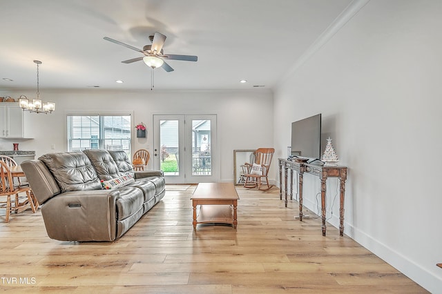 living room with ceiling fan with notable chandelier, light wood-type flooring, and crown molding